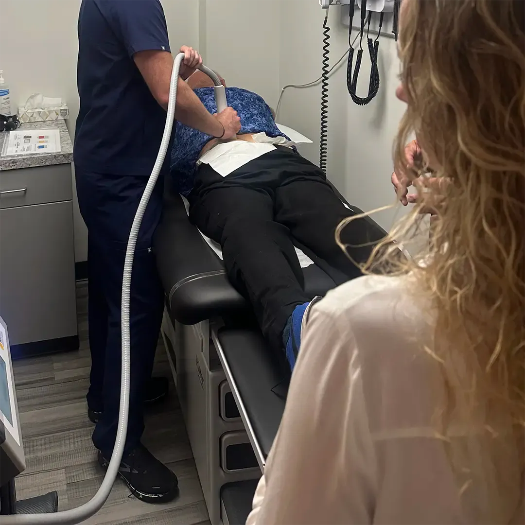 LPN standing next to a bed in a hormone replacement therapy treatment room
